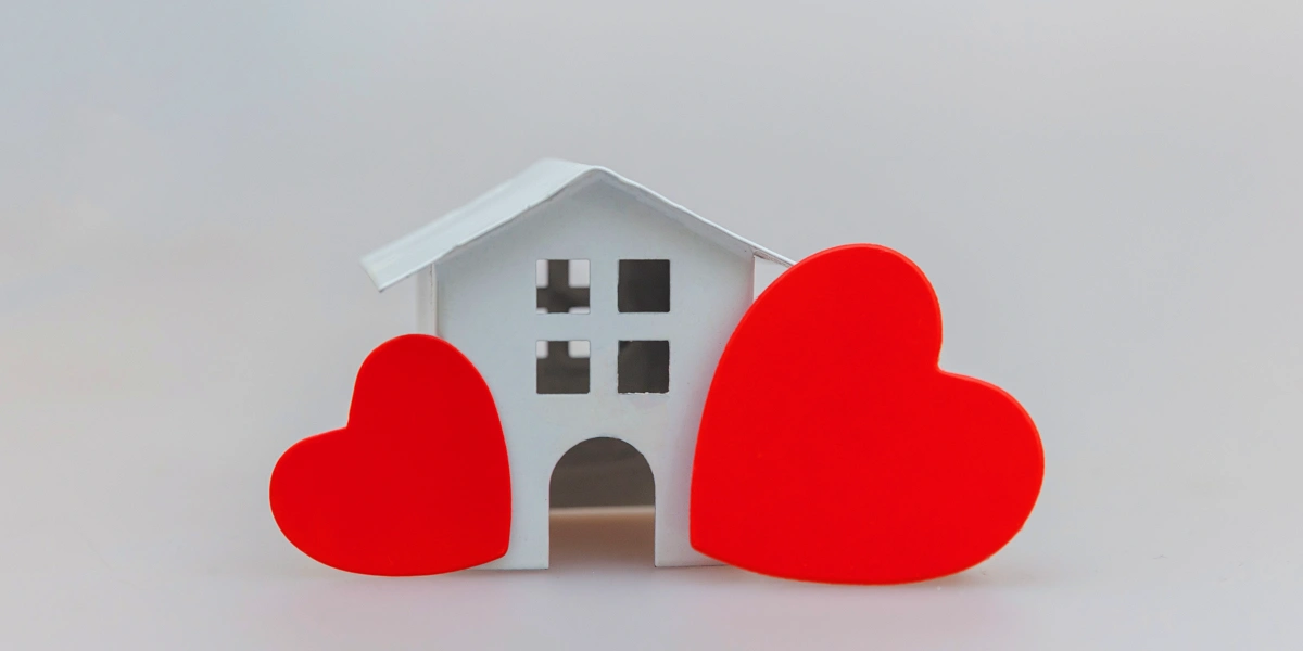 Equipa tu Casa con Infonavit: Casa blanca y corazones rojos